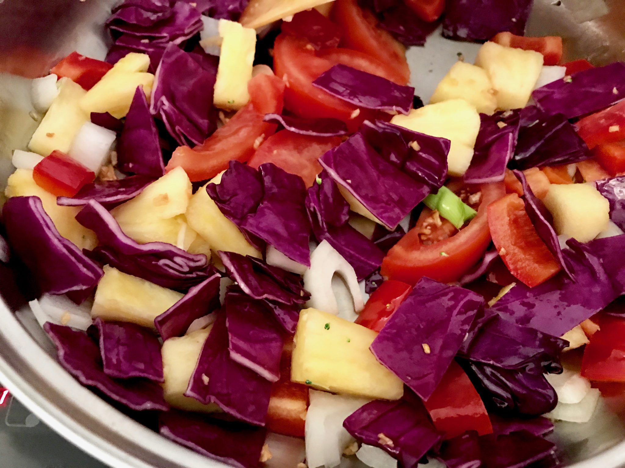 stir fry onion, red cabbage, tomatoes, and pineapples first