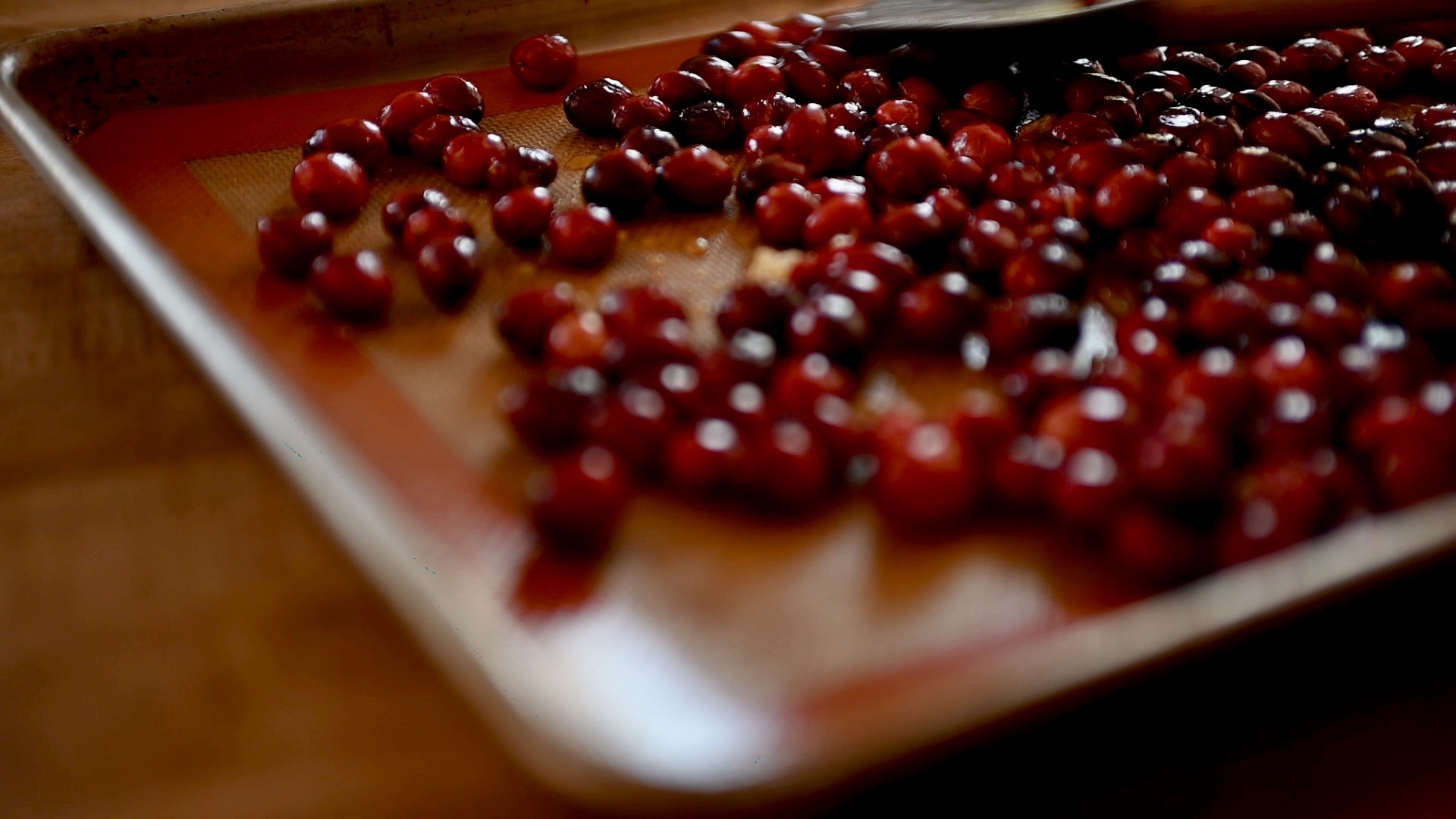 a single layer of cranberries on a sheet pan